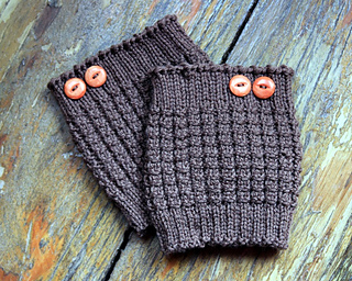 A close up of a pair of boot cuffs laid against a wooden background.
