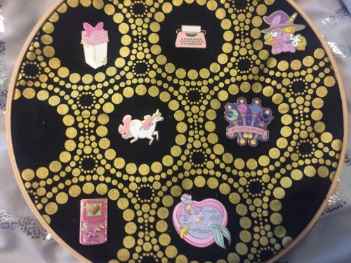A display of pink and purple enamel pins