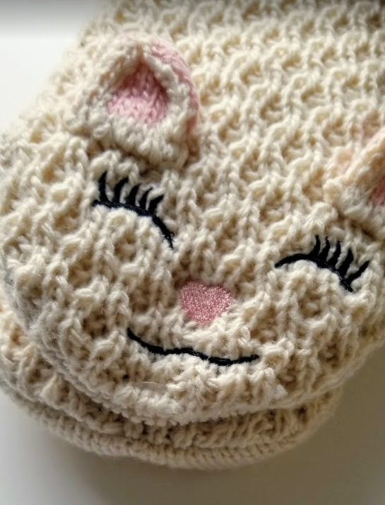 Close up of adorable smiling cat face stitched onto flipper socks 
