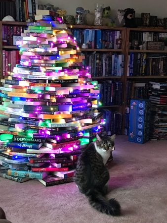 Fisher sits in front of the finished Bookmas Tree.