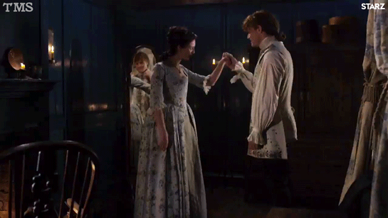 Claire in a pale grey gown embroidered with vines and flowers, curtseying to Jamie (wearing a waistcoat but no jacket).