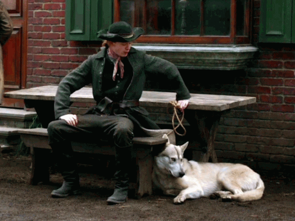 Ian sitting at a table with his giant wolf dog, Rollo. Honestly, I pictured Rollo to be more gray and less fawn colored.