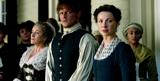 Jocasta, Jamie, and Claire, with Phaedre behind them, watching the desecration of Rufus' body.