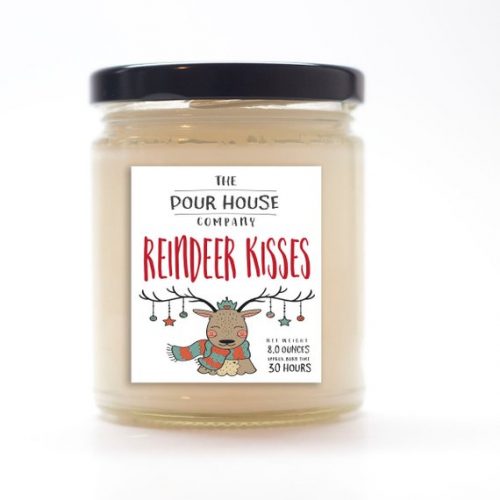 A beige candle in a glass jar with a black metal lid. The label has an adorable cartoon reindeer on it.