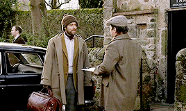 Roger talking to the cabbie dude. Roger is wearing a coat over a sportcoat over a dress shirt over a turtle neck and it's not a good look, honestly.