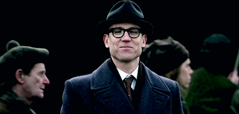 Frank, in the midst of 18th Century Ayr, smiling and nodding at Brianna.