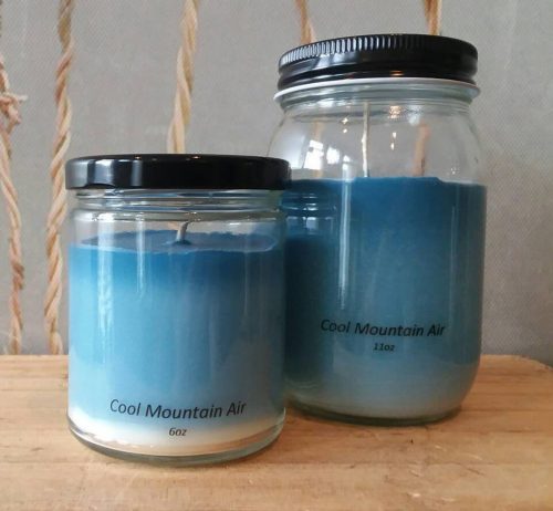 Two ombre blue candles in glass jars. One medium and one large, with black metal lids.