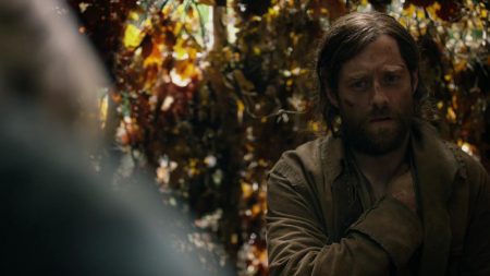 Roger grimaces in pain and holds his shoulder