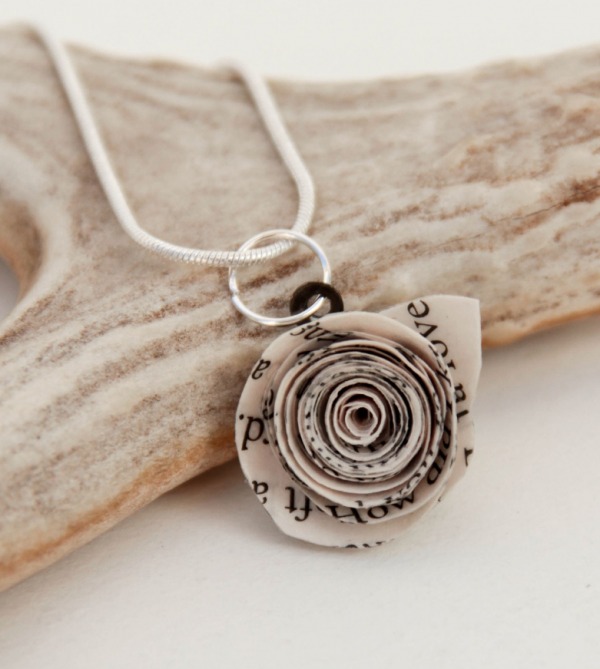 A paper rose necklace with a silvertone chain made from a page of Pride and Prejudice