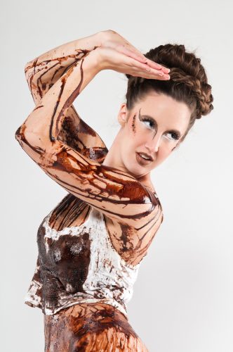 Tall brunette covered in chocolate syrup and coffee grounds