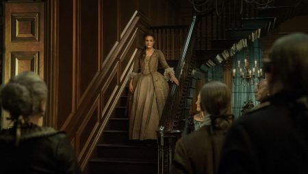 Bree comes down the staircase to meet the assembled guests.