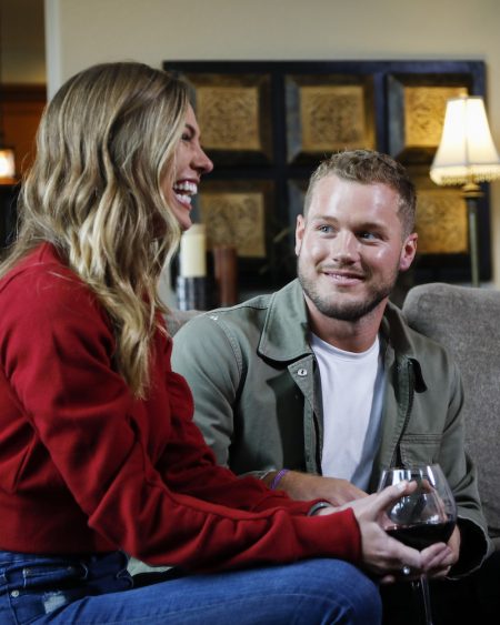 Hannah B laughs as she holds a glass of wine. Colton smiles at her.