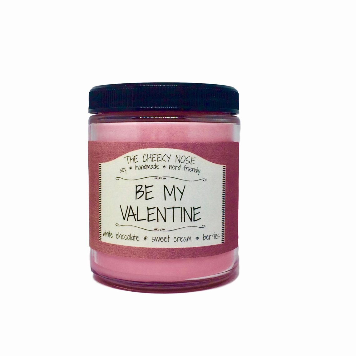 A bright pink candle in a glass jar with a raspberry colored label