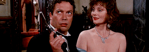 A GIF from the movie Clue where Tim Curry is trying to remember how many bullets are left in the gun