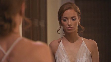 Elyse looks at herself in the mirror