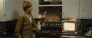 Jennifer Lawrence clutches her chest while the microwave catches fire