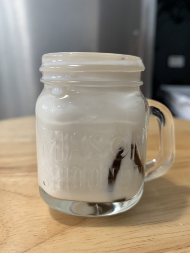A dairy-based cocktail with a drizzle of chocolate syrup in a mason jar