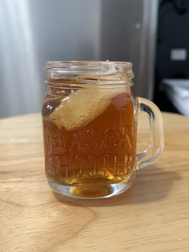 A light amber colored cocktail in a mason jar