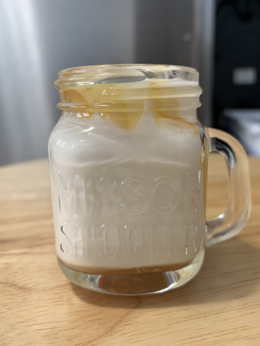 A dairy cream bourbon cocktail in a mason jar with a caramel sauce drizzle