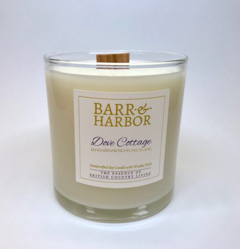 A white candle in a glass jar with a square, wood wick.