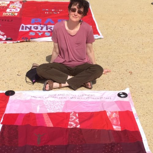 Cleo sitting down next to her quilt square