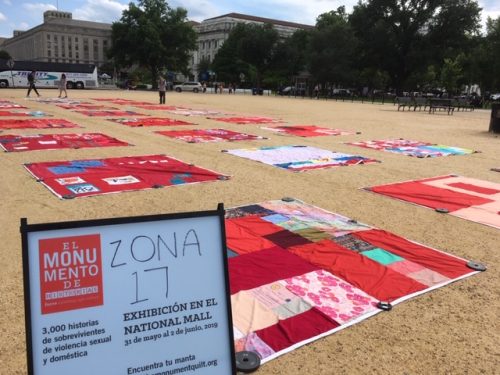 A collection of red quilts on display