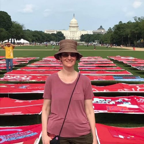Cleo standing in front of the quilt display with the White House in the background