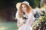 Portrait of a beautiful woman with curly hair outdoors in a spring park