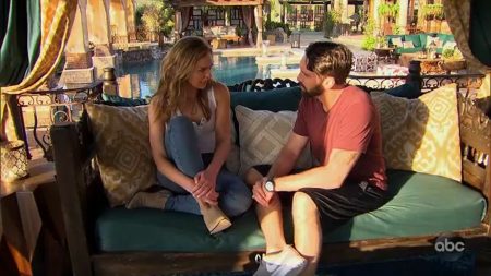 Hannah and Cam sit on a bench and talk.