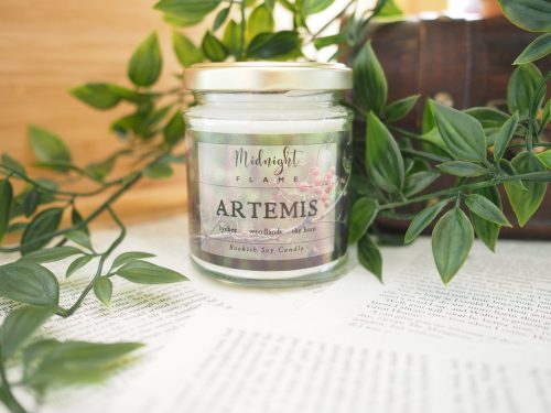 A candle in a glass jar with a muted, floral label.