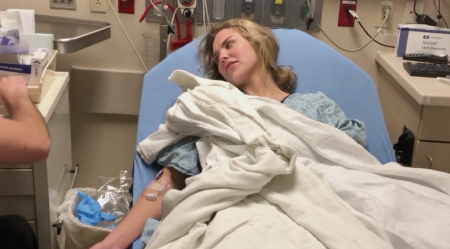 Hannah lays in a hospital bed getting IV fluids.