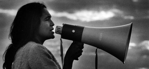A young Dolores speaking into a megaphone