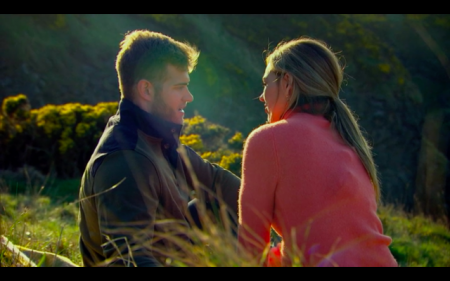 Hannah and Luke sit on a hillside and talk