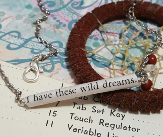 Recycled Book Bar Necklace - a tube of text that reads "I have these wild dreams"