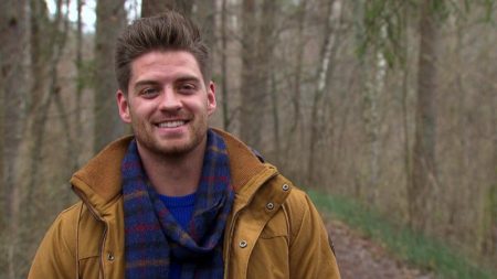 A close up of Garrett standing in the forest