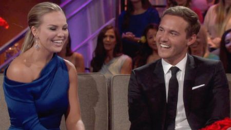 Hannah sits next to Peter on a sofa in a LA studio