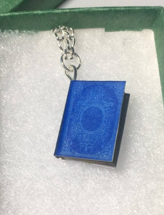 A miniature vintage blue book in a jewelry box