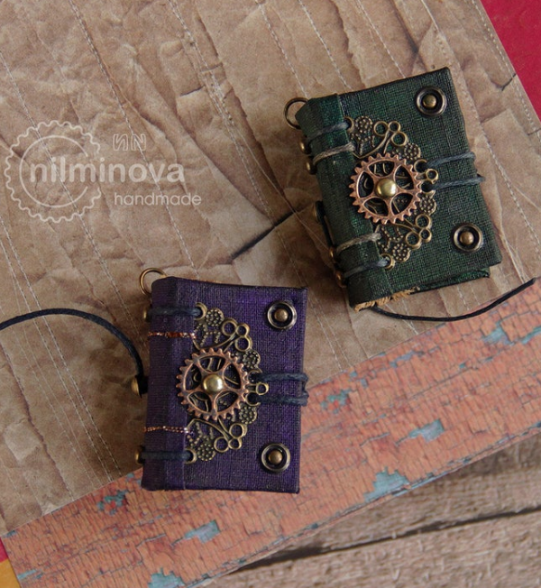 Miniature green abd purple books embellished with tiny brass charms and gears