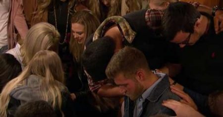 A youth group prays over Luke and Hannah