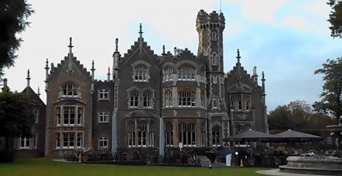 exterior of Oakley Court with crenellations, stone inset windows and lots of gothic flair