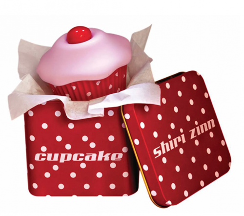 A pink and red cupcake shaped vibrate in a red and white polka dot tin case.
