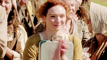 Demelza from Poldark claps and looks utterly delighted and pleased