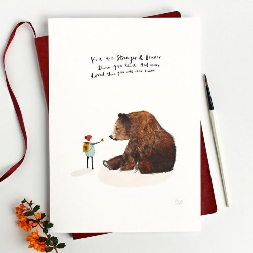 A print of a hiker offering a apple to a bear with the text, "You are stronger and braver than you think. And more loved than you will ever know."
