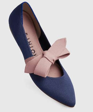 A blue pointed flat with a pink ribbon tied over the instep