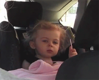 a little girl in a carseat rolls her eyes