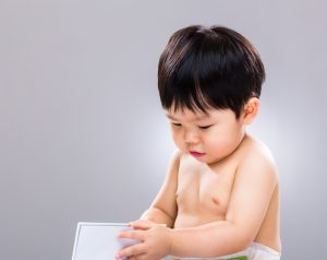 Cute little child playing with book looking very thoughtful