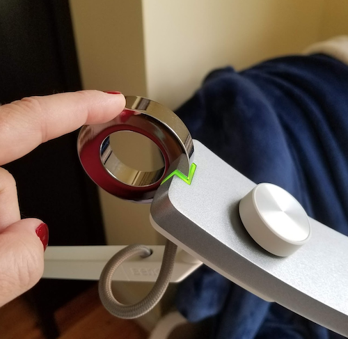 my finger turning the lamp on by touching a metal ring on the back of the head of the lamp 