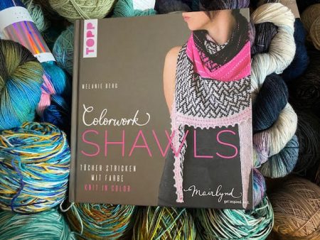Melanie Berg's book Colorwork Shawls sits on top of a pile of yarn