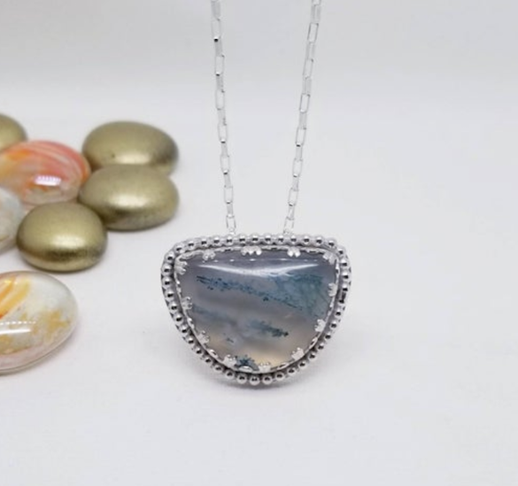 light light blue agate necklace pendant in a half moon shape surrounded by silver 