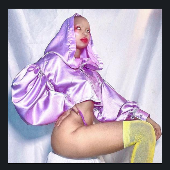 A fluffy satin hooded blouse is a deep lavendar with long puffy sleeves and a cropped length it's really gorgeous